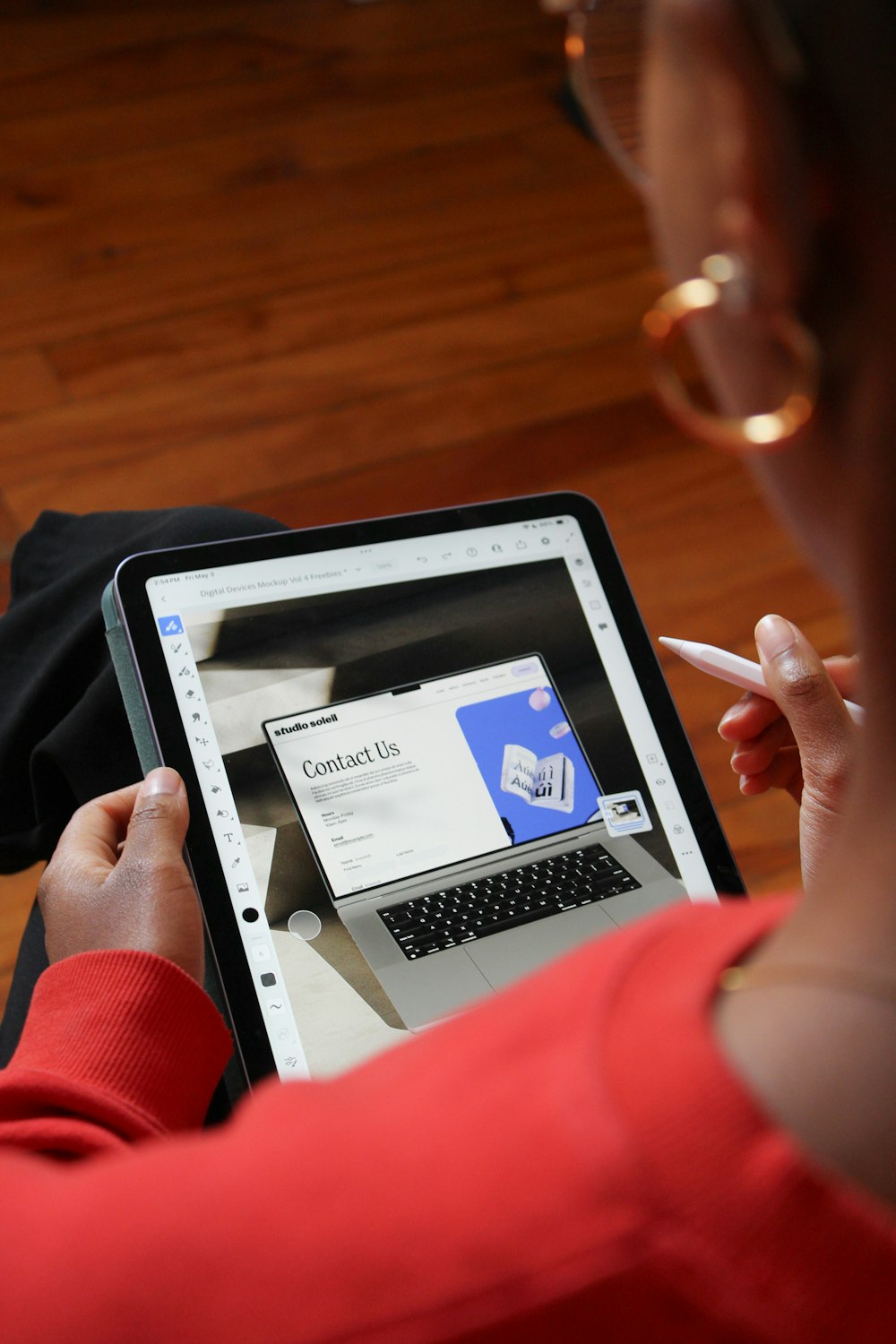 a woman using a laptop computer on a wooden floor