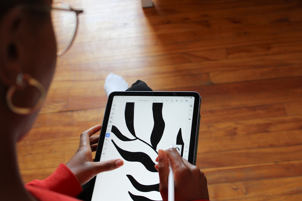 a woman holding a tablet with a zebra print on it