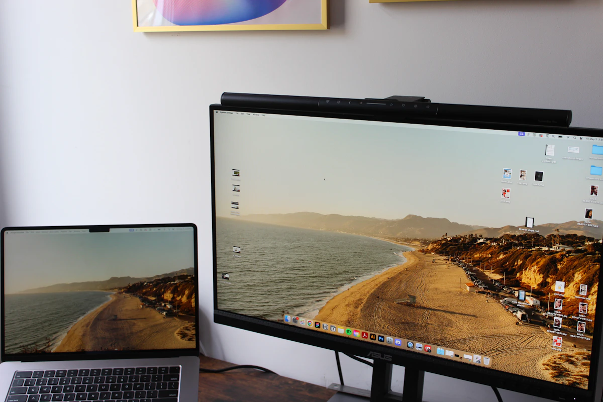 a laptop computer sitting on top of a desk next to a monitor