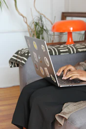 a woman sitting on a couch using a laptop computer