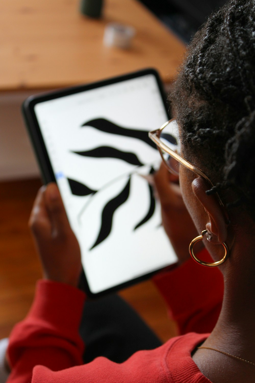 a woman with glasses is looking at a tablet