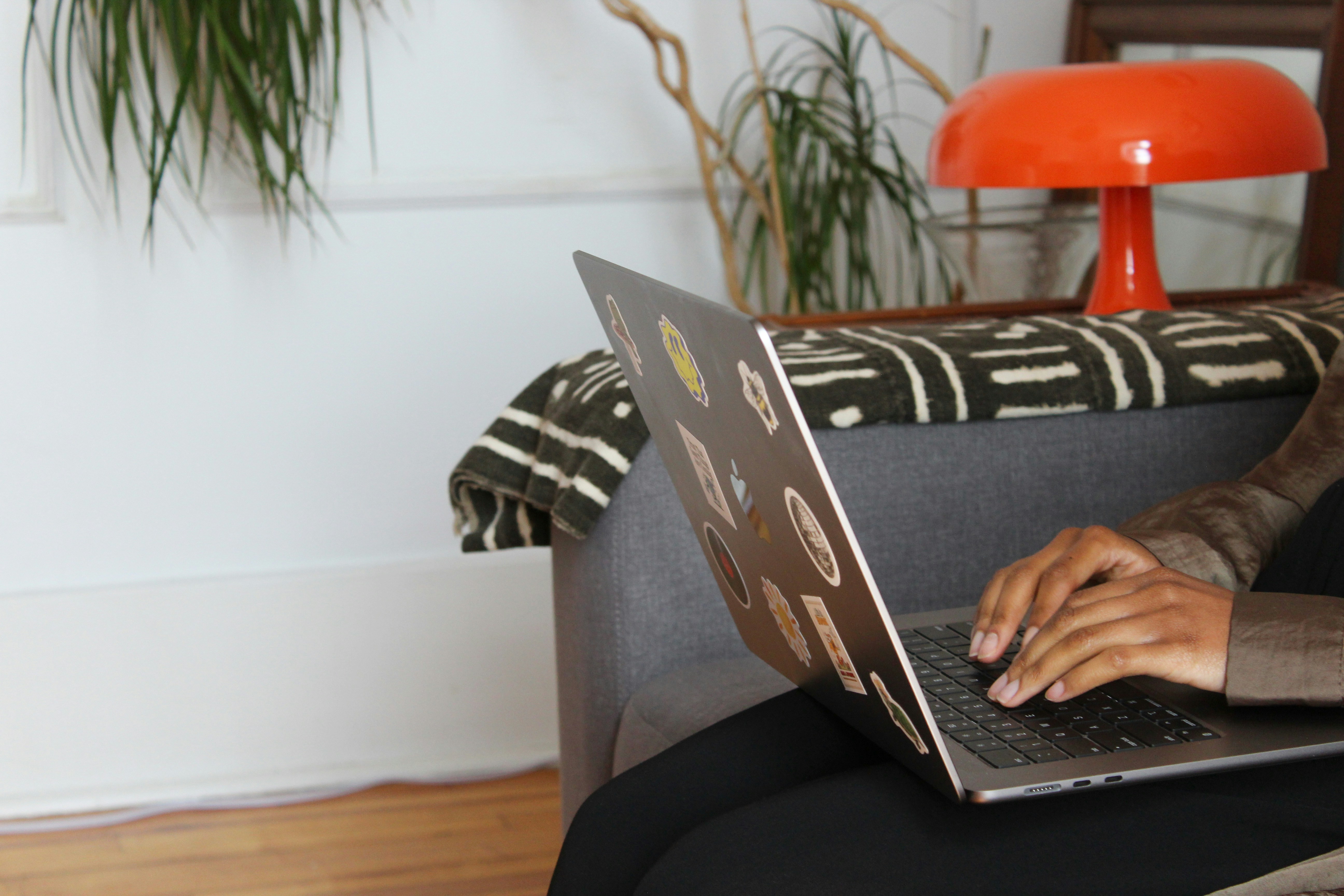 a woman sitting on a couch using a laptop computer
