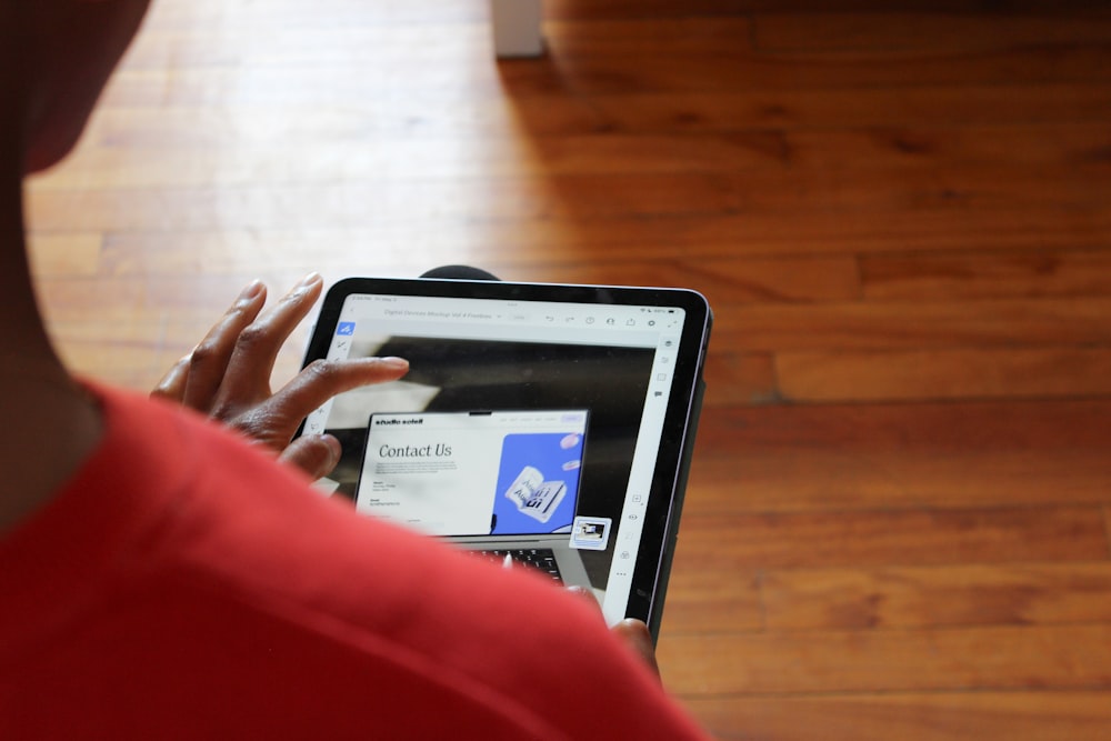 a person using a laptop computer on a wooden floor