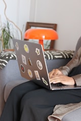 a woman sitting on a couch using a laptop computer