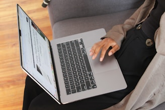a person sitting on a couch using a laptop computer