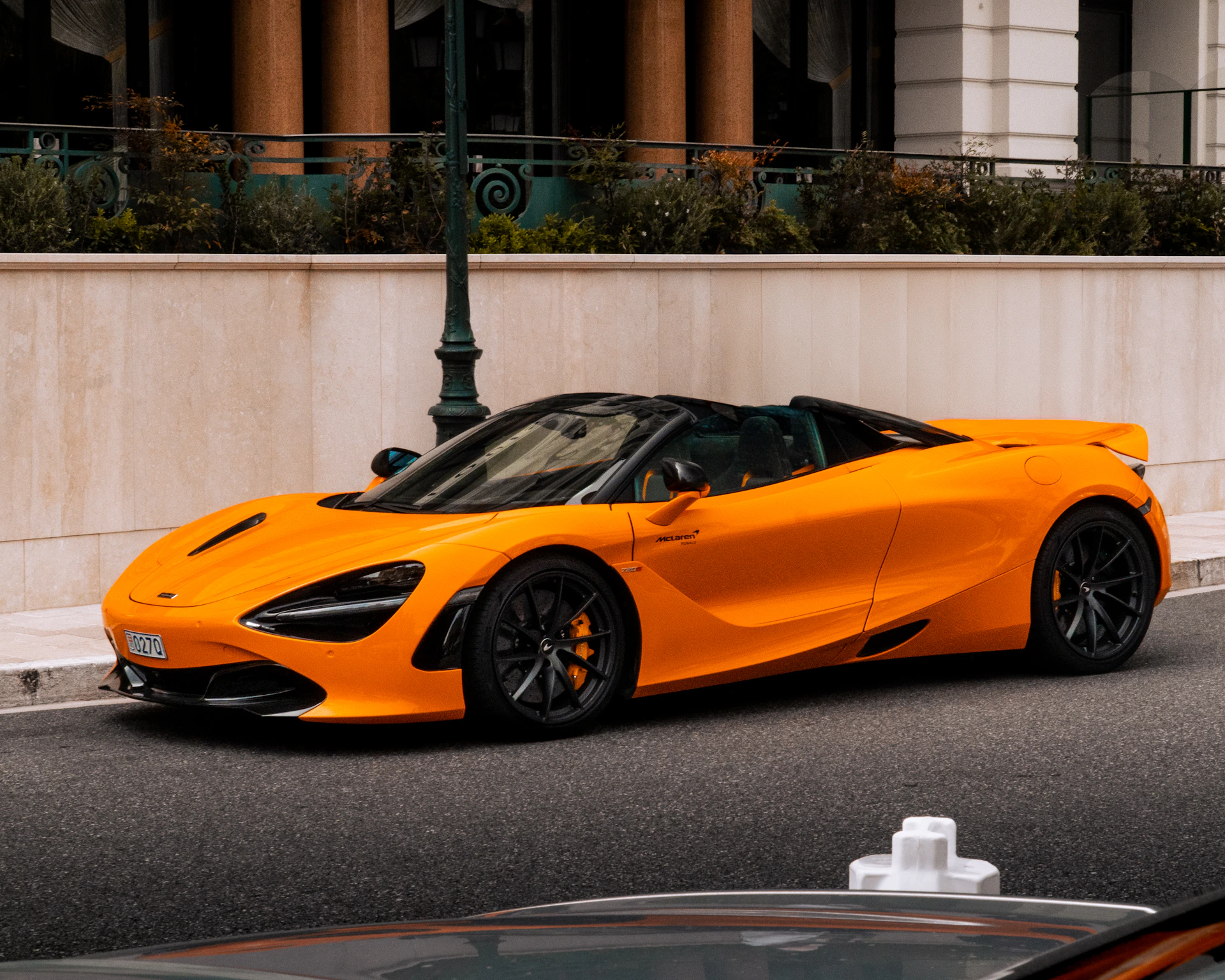 an orange sports car parked on the side of the road