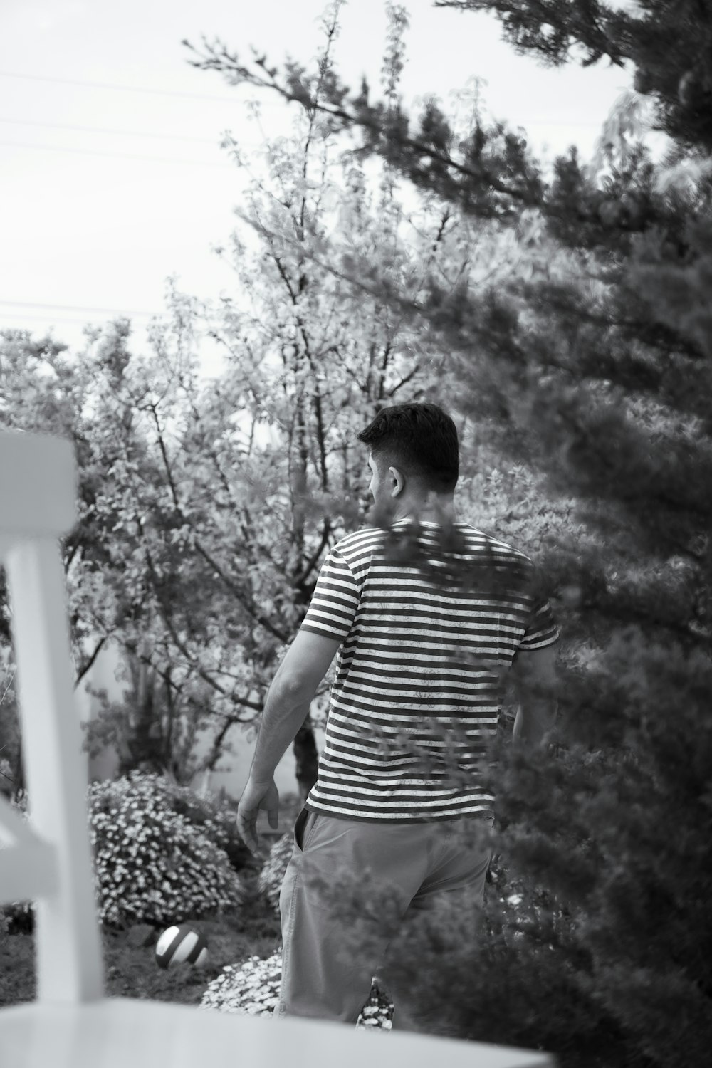 a man standing next to a white chair