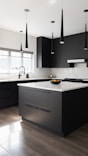 a modern kitchen with black cabinets and white counter tops