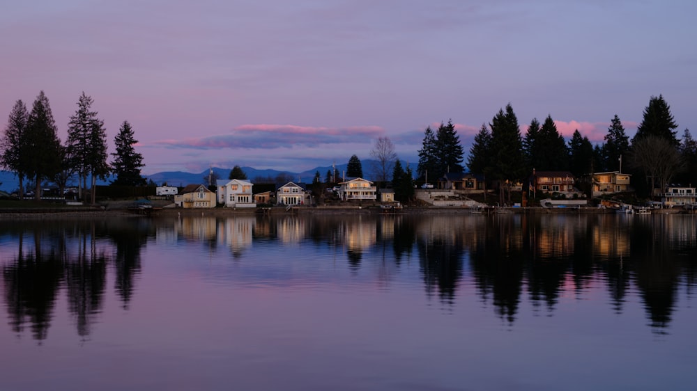 a body of water with houses and trees in the background