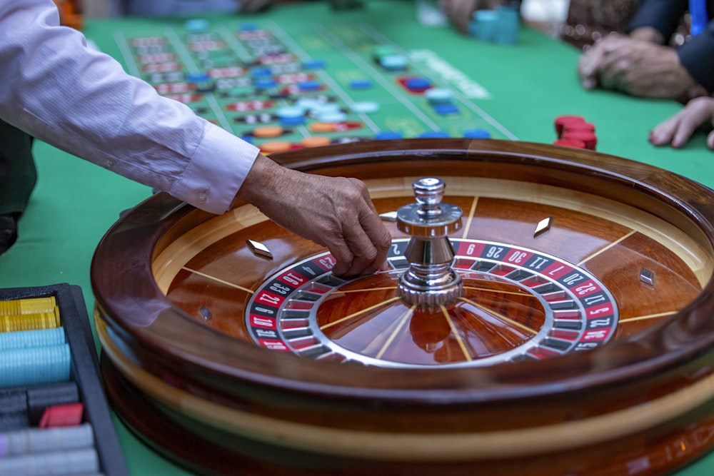 a man is playing a game of roule on a green table