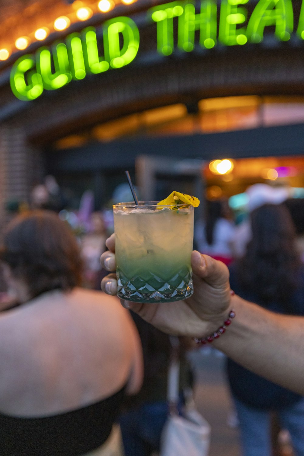 a person holding a drink in front of a building