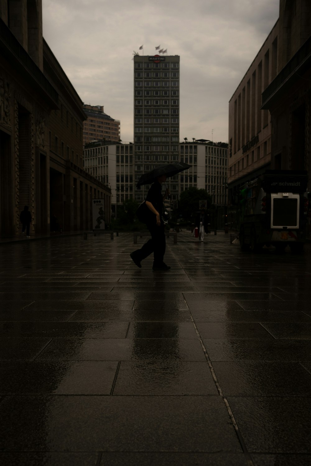 a person walking down a street holding an umbrella