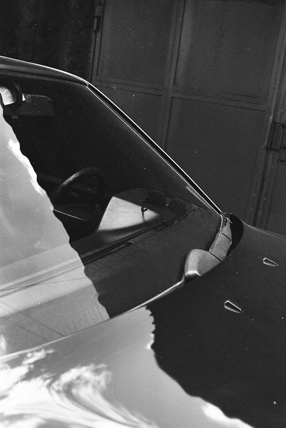 a black and white photo of a car parked in a garage