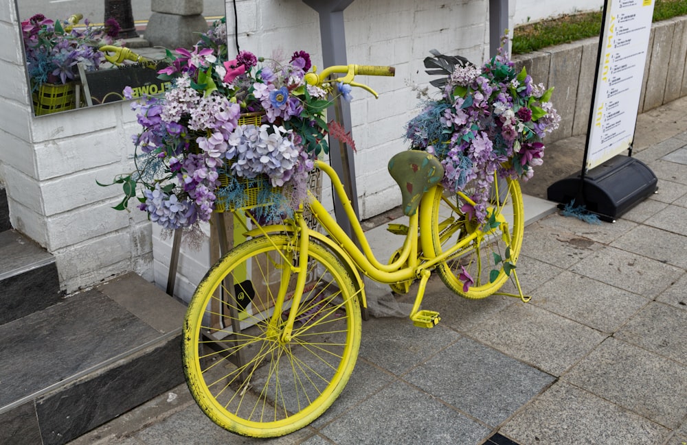 a yellow bicycle with flowers in the basket
