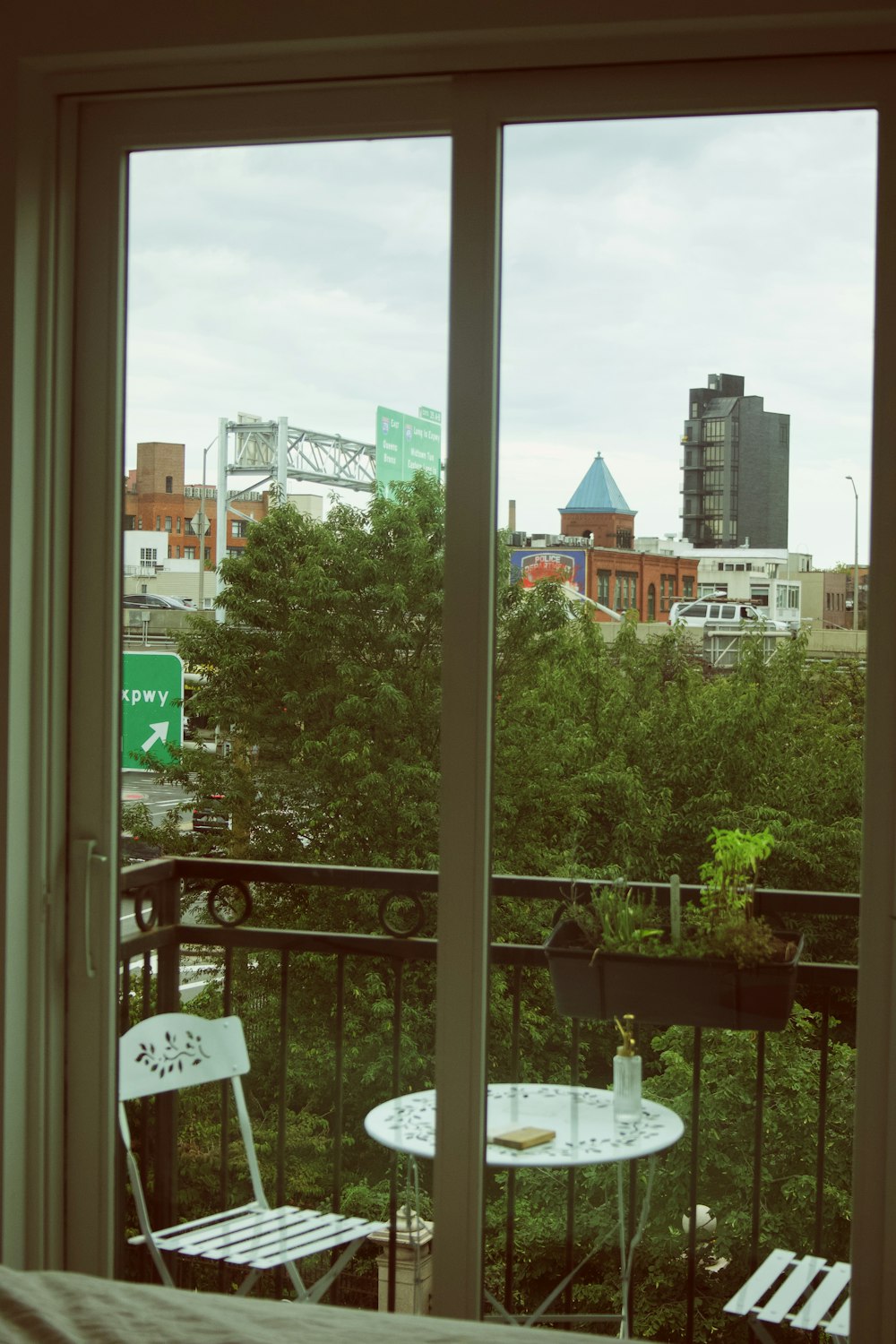 a balcony with a table and chairs and a view of a city