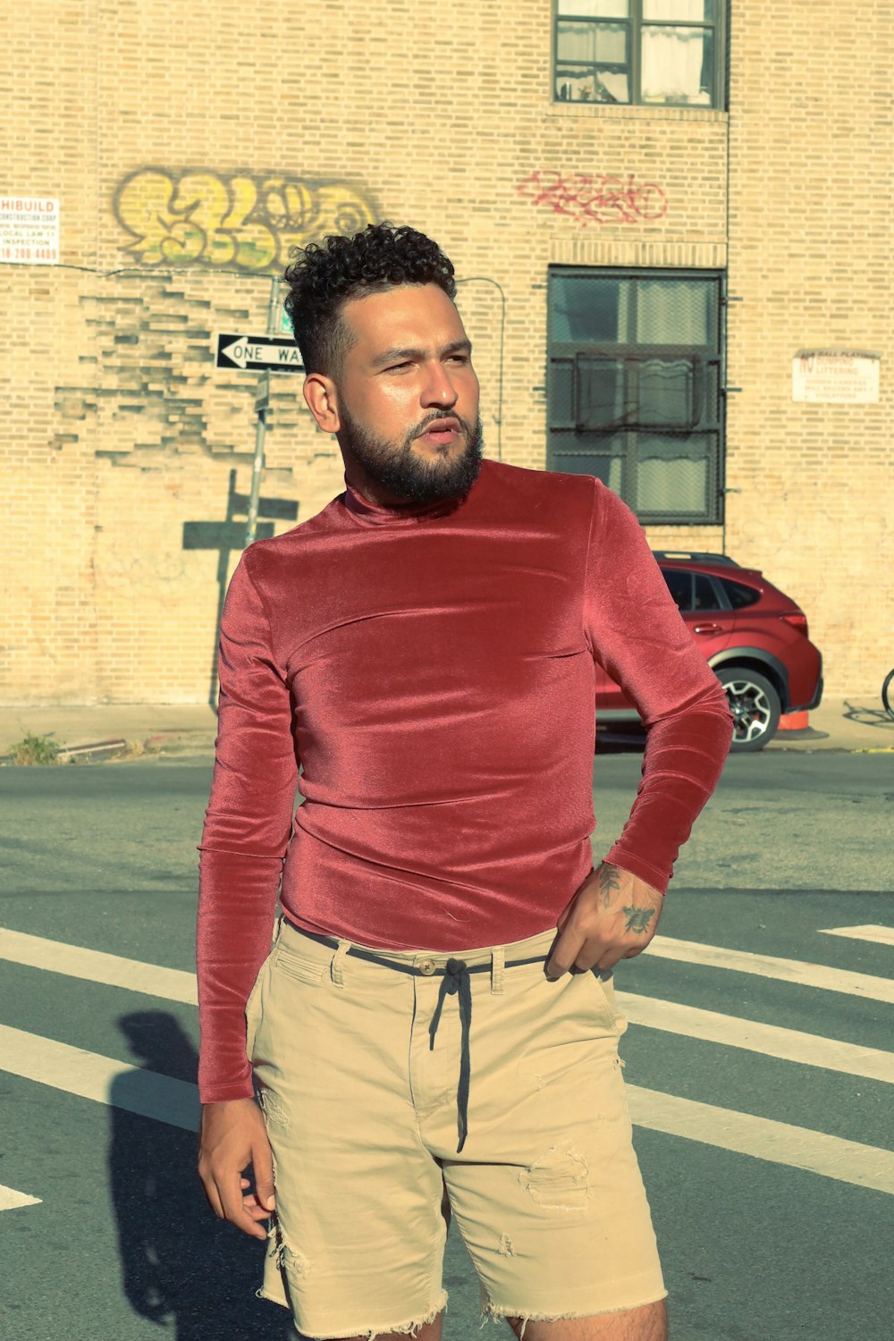 a man in a red shirt and tan shorts