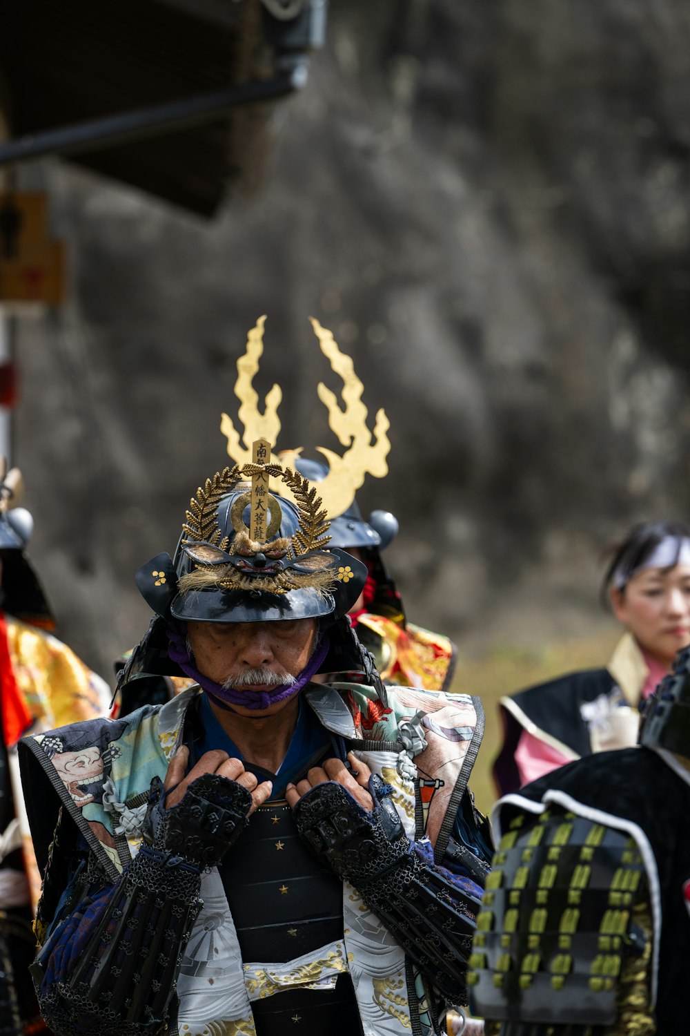 a man dressed in armor and holding his hands to his face