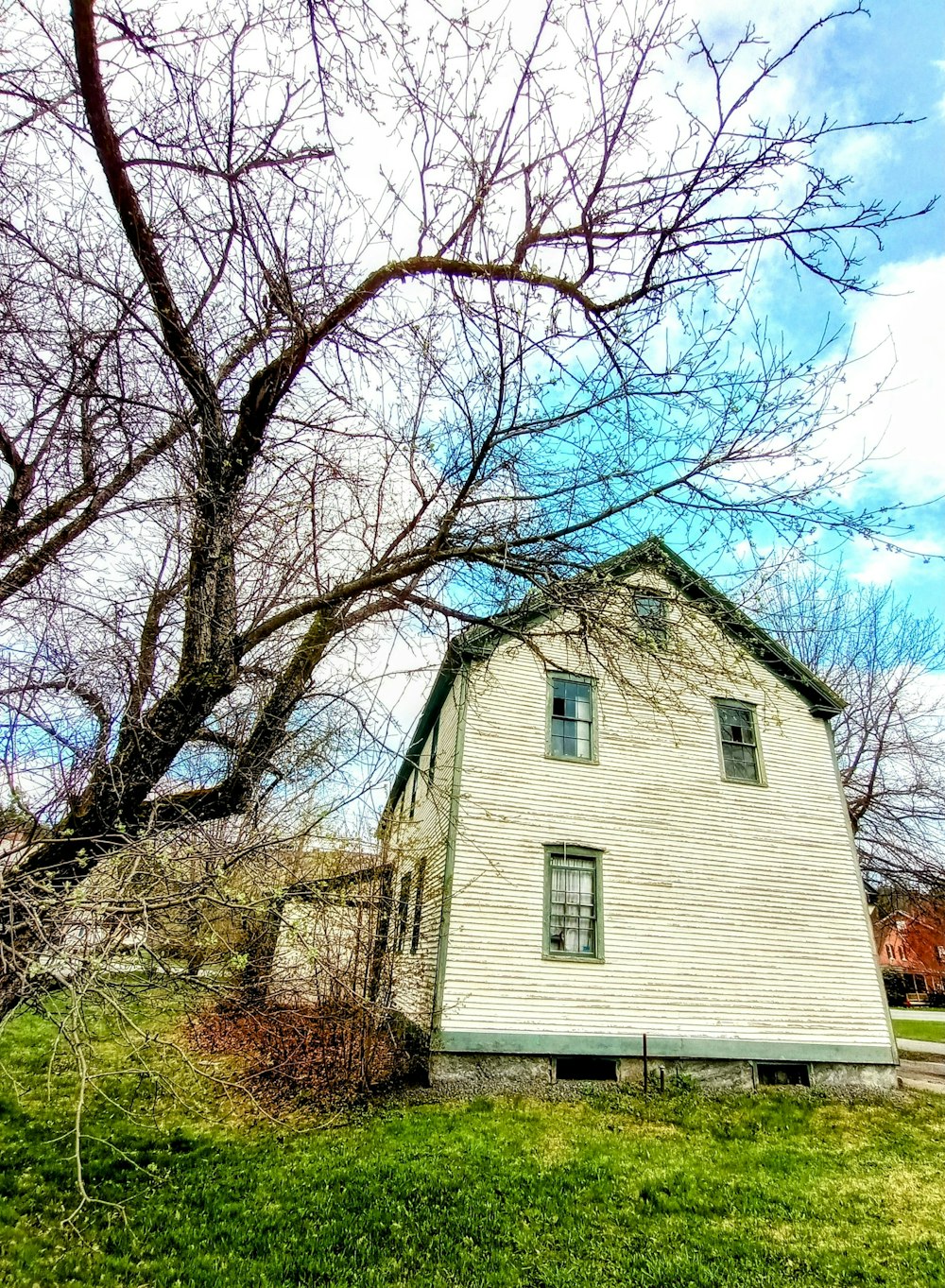 a white house sitting in the middle of a field