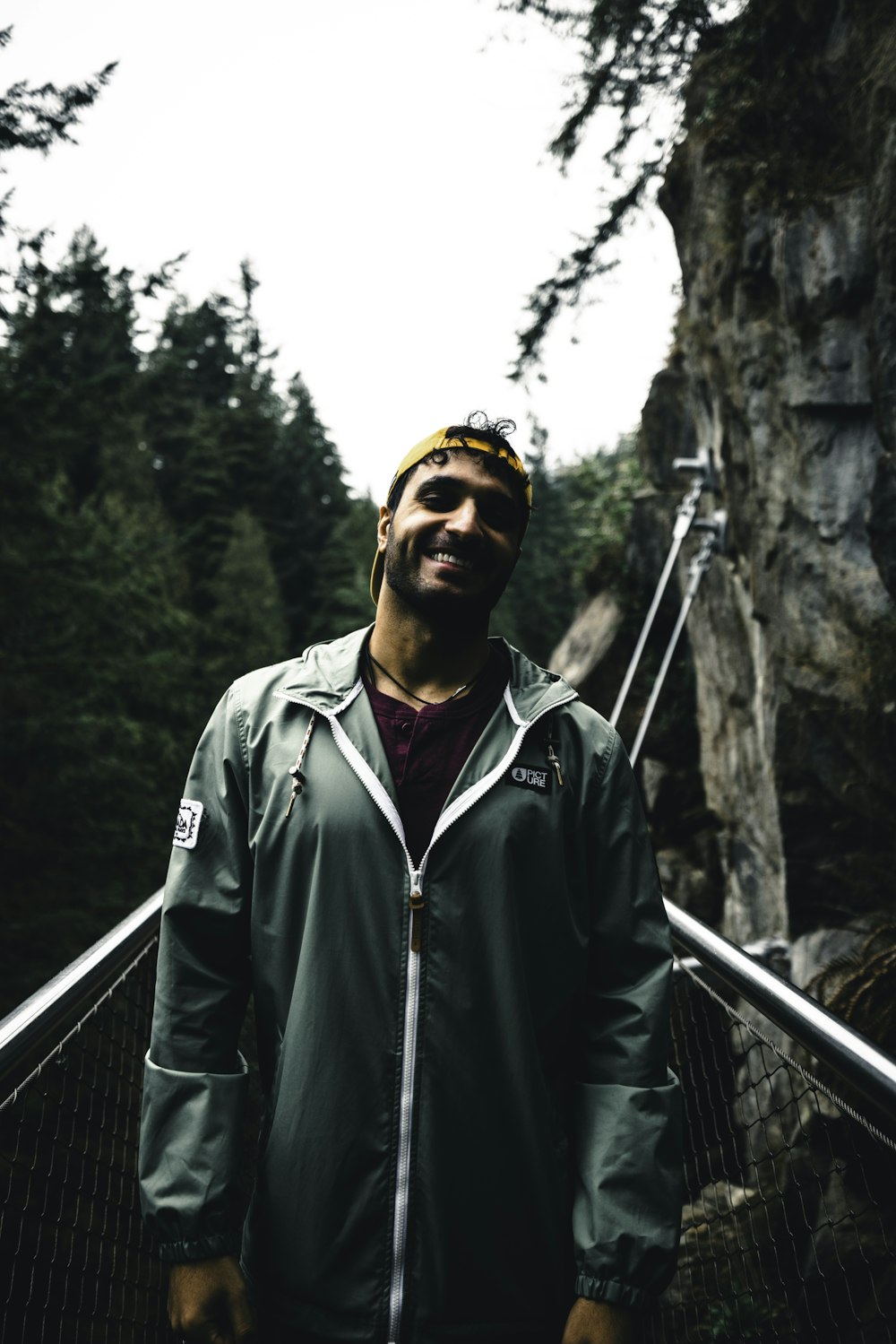 un uomo in piedi su un ponte nel bosco
