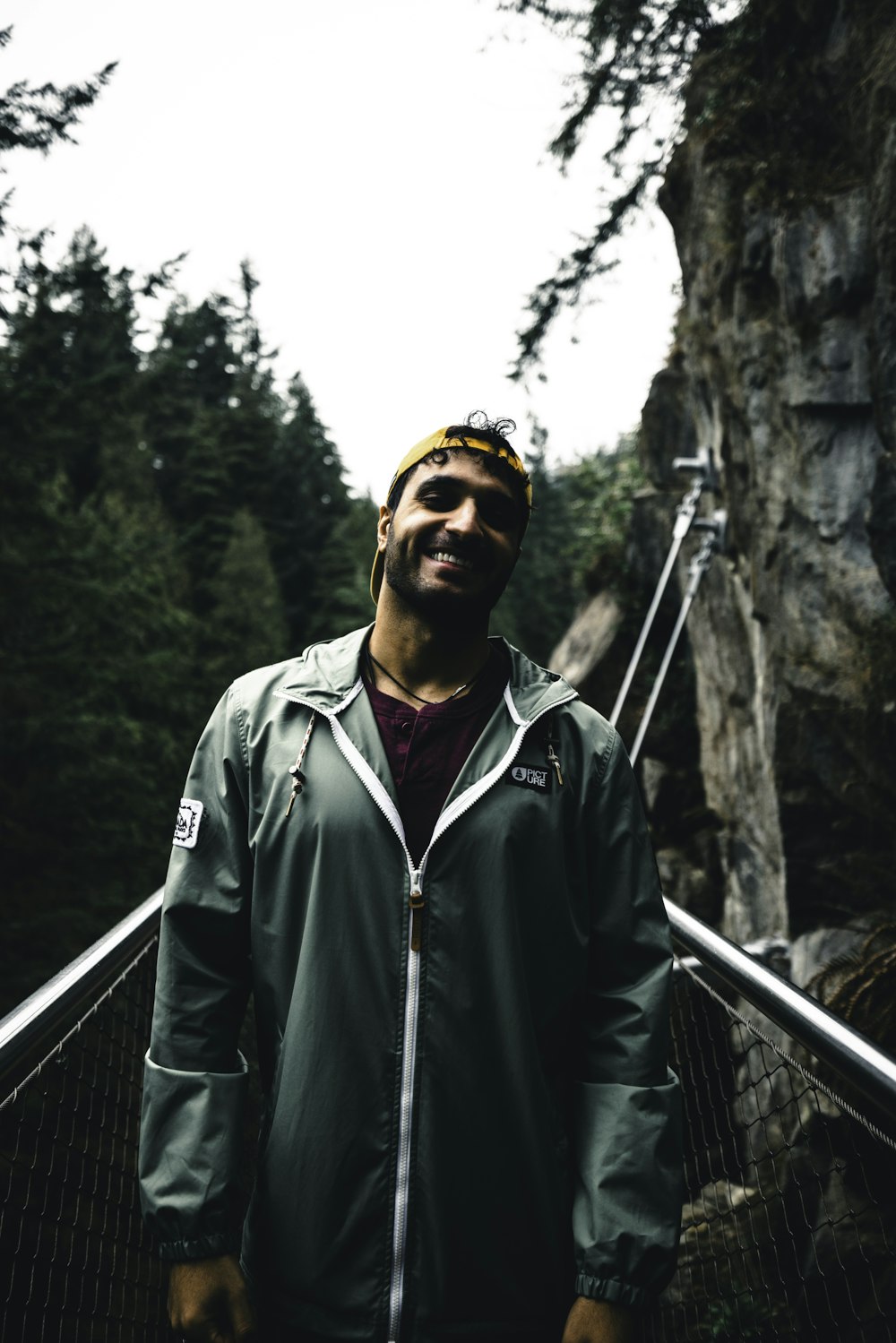 a man standing on a bridge in the woods