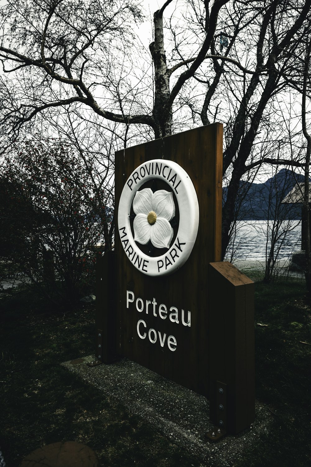 Ein Schild für Portreau Cove vor einem Baum