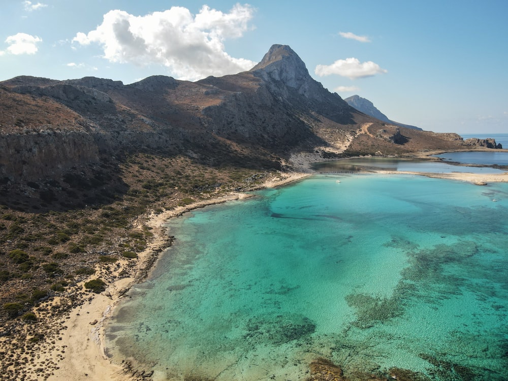 an aerial view of a beach with clear blue water