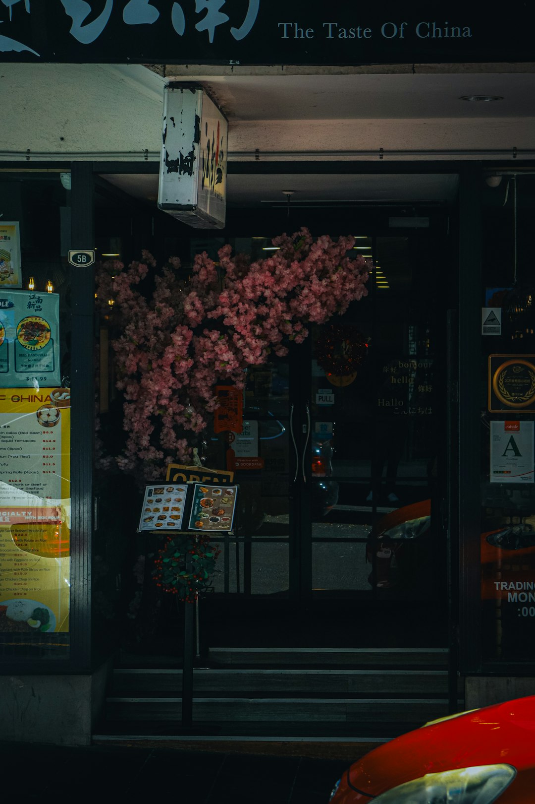 A traditional Chinese restaurant with a beautiful cherry blossom tree at the front.