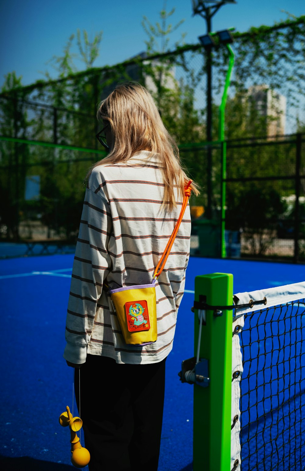 a woman standing on a tennis court next to a net