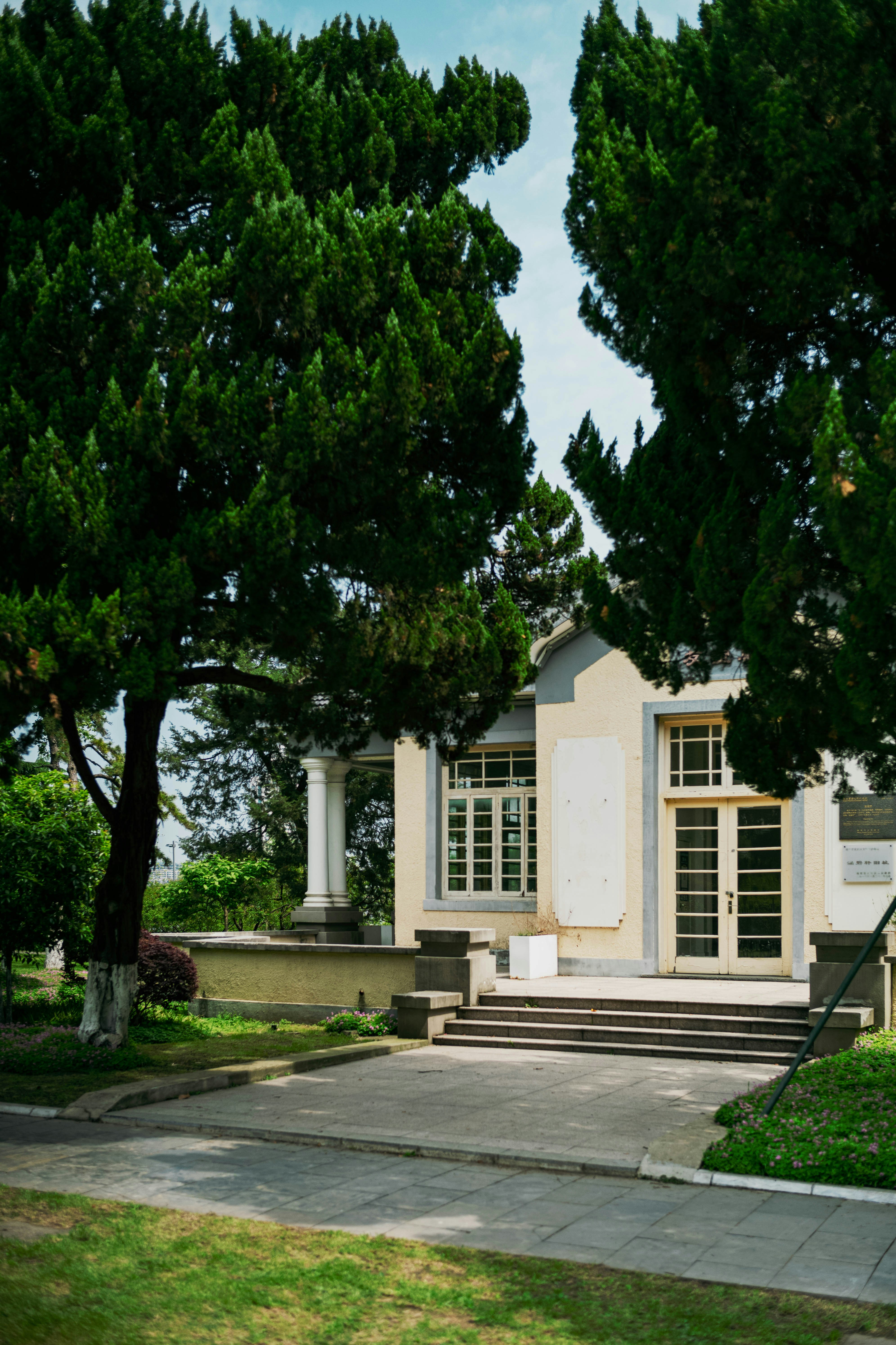 a small white house with trees in front of it