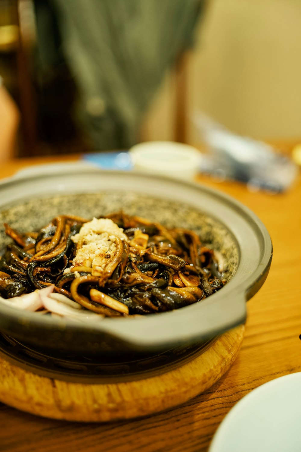 a wooden table topped with a bowl of food