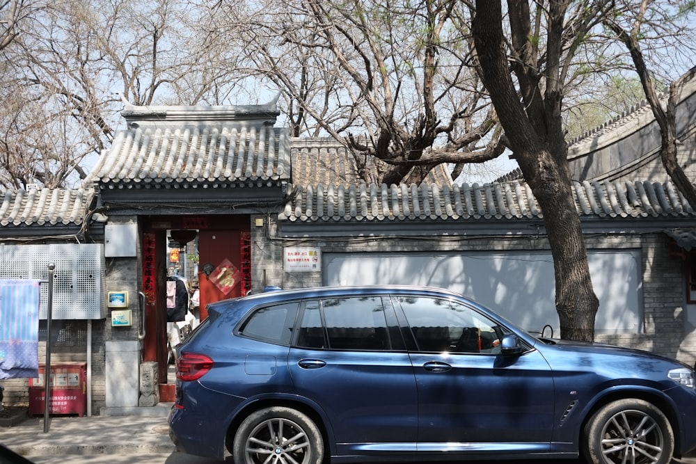 a blue car parked in front of a building