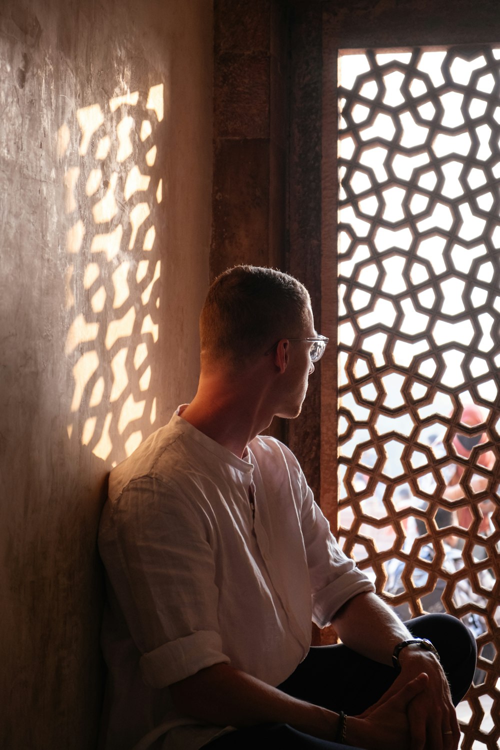 a man sitting on a bench in front of a window