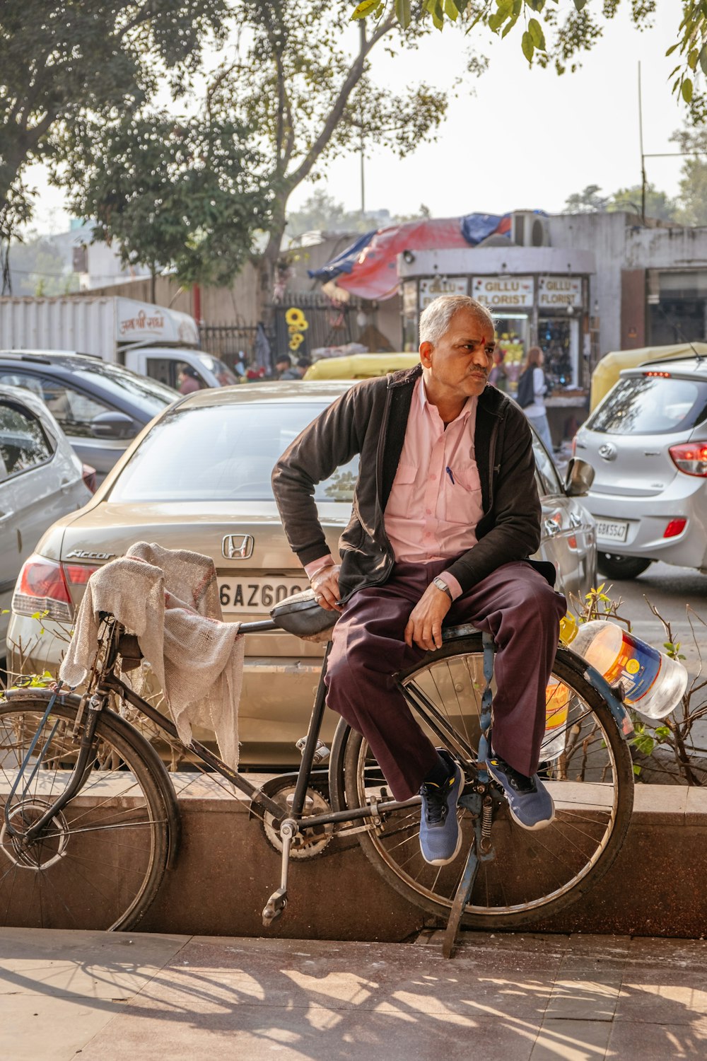 a man sitting on a bike on the side of the road