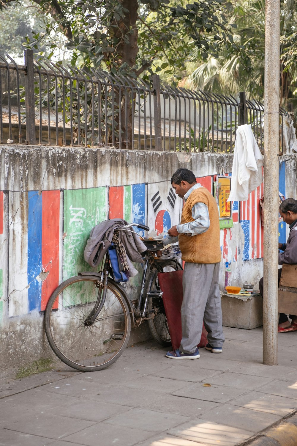 a man standing next to a bike next to a wall