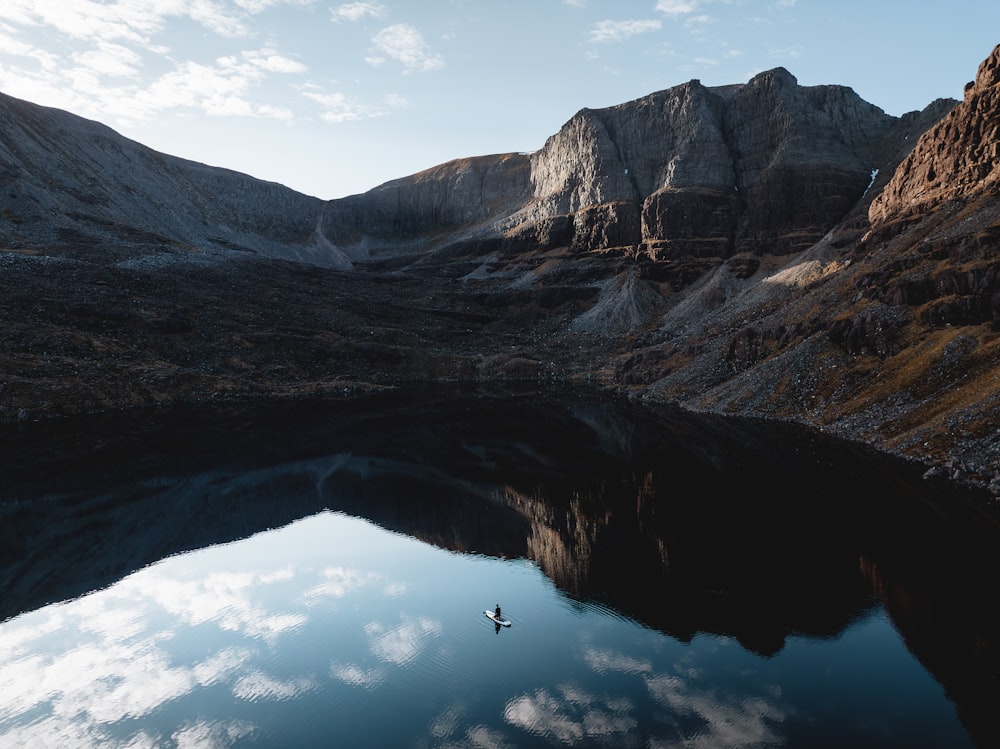 Un barco solitario flotando en un lago rodeado de montañas