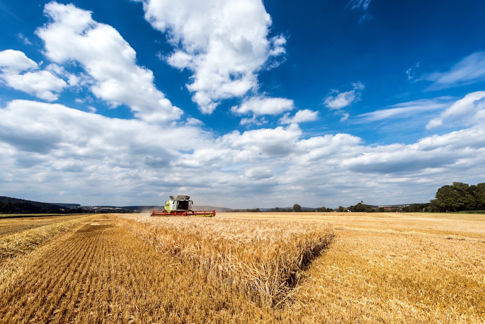 a combine truck driving through a wheat field