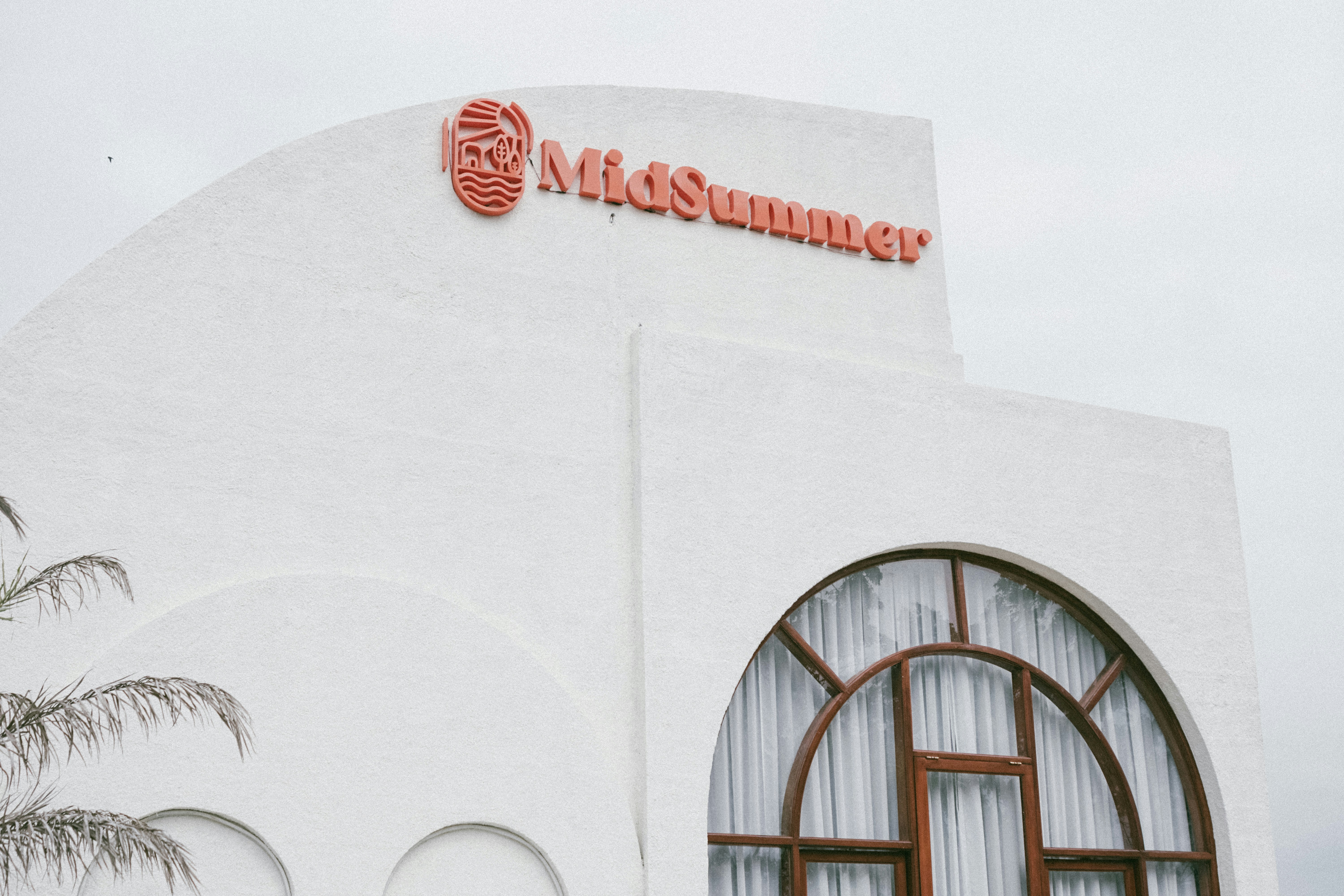 a tall white building with a red sign on it's side