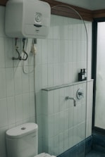 a white toilet sitting next to a walk in shower