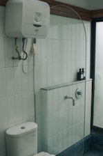 a white toilet sitting next to a walk in shower