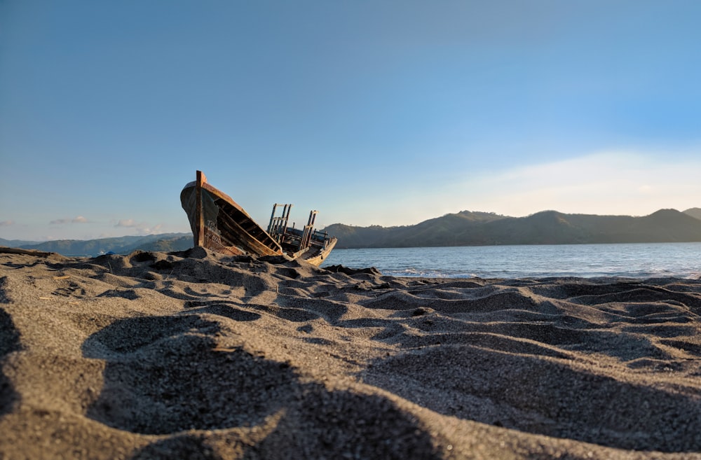 Un barco sentado en la parte superior de una playa de arena