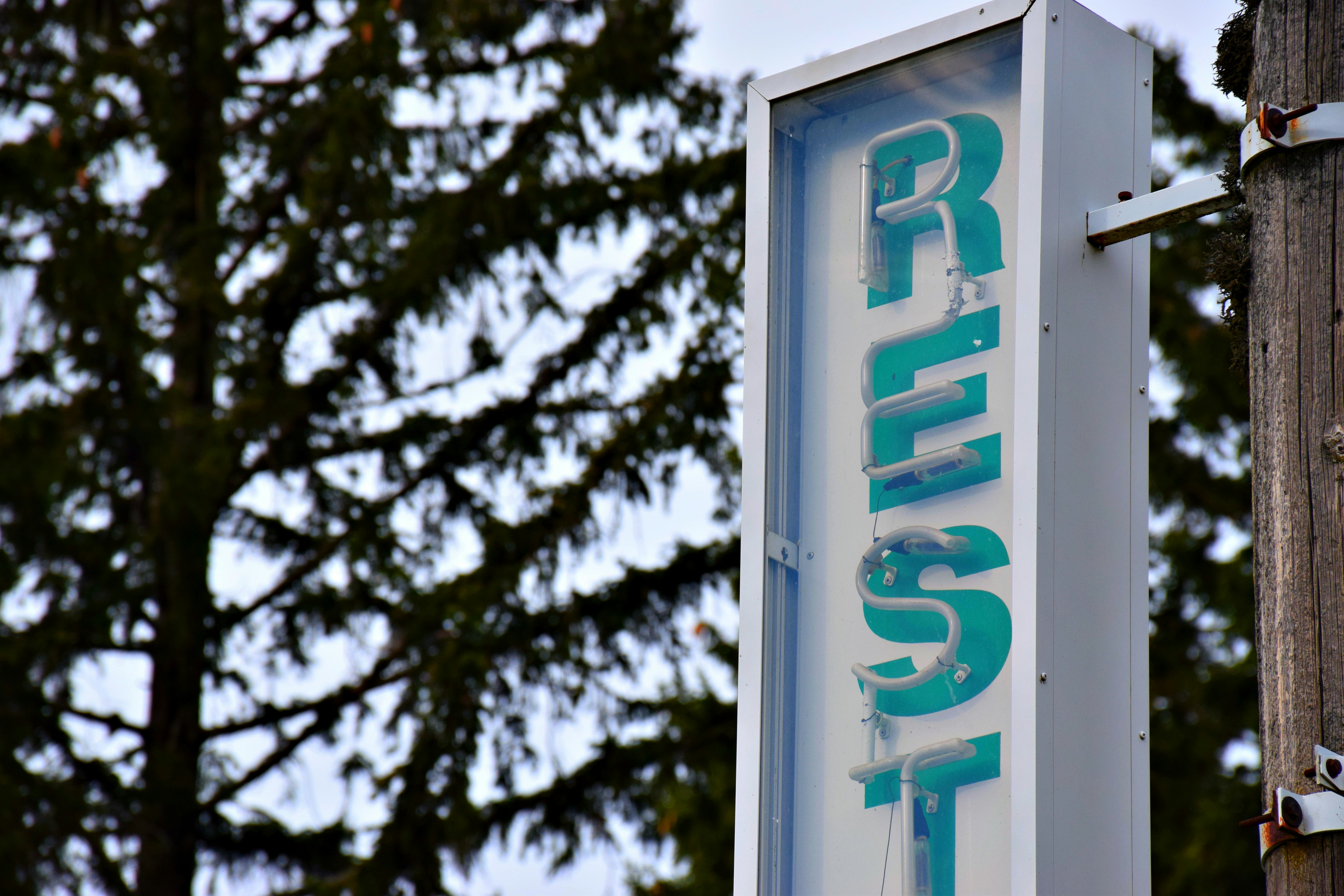 a sign on a telephone pole with trees in the background