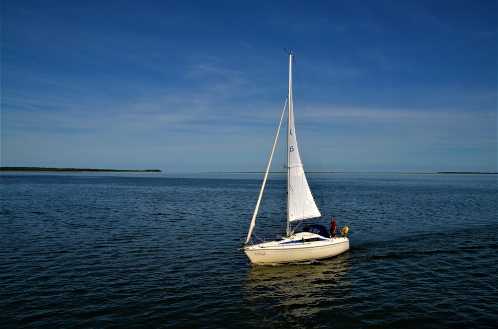 a white sailboat floating on top of a body of water