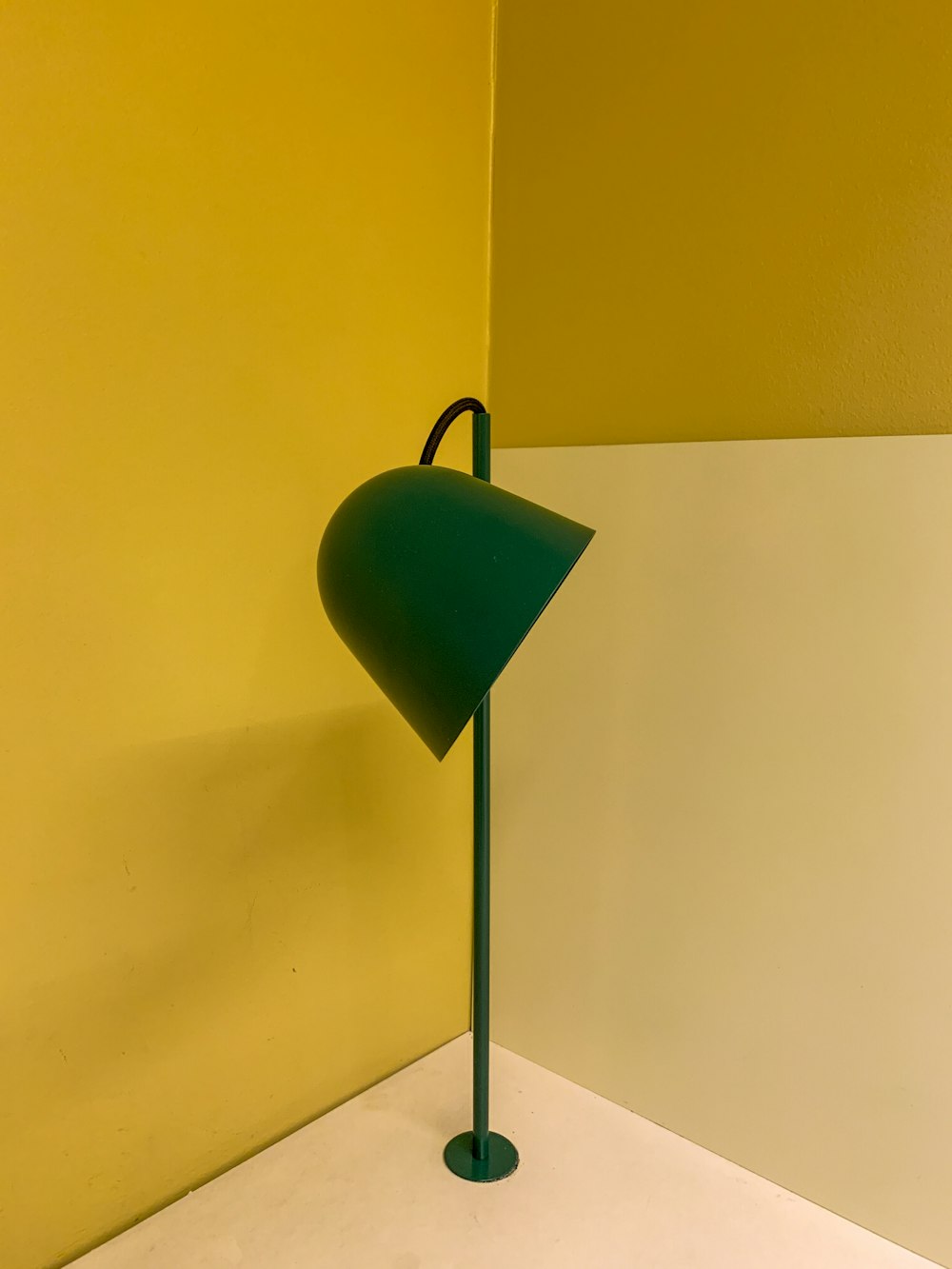 a green lamp sitting on top of a white floor