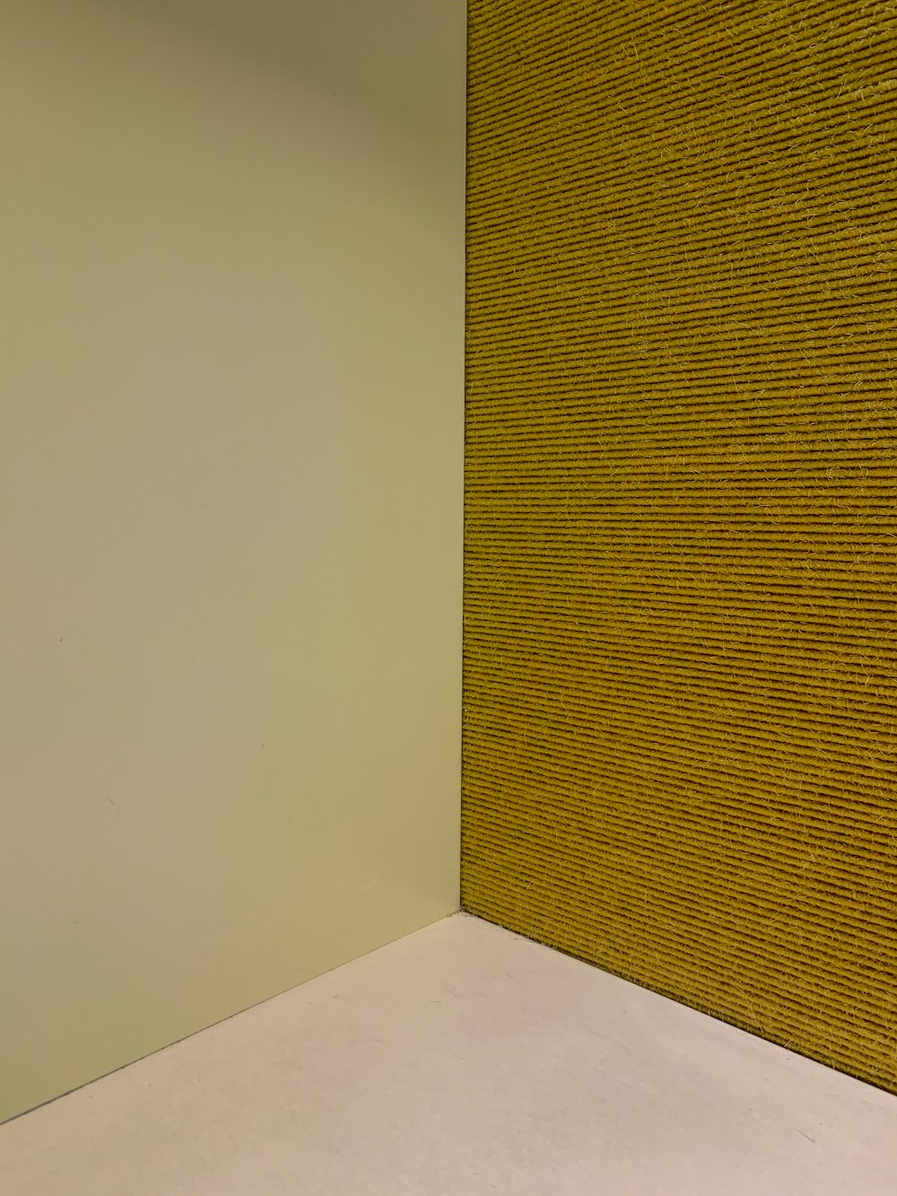 a corner of a room with a yellow wall