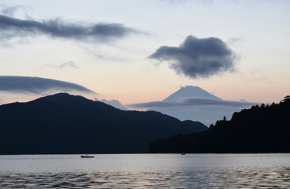 a boat floating on top of a lake under a cloudy sky