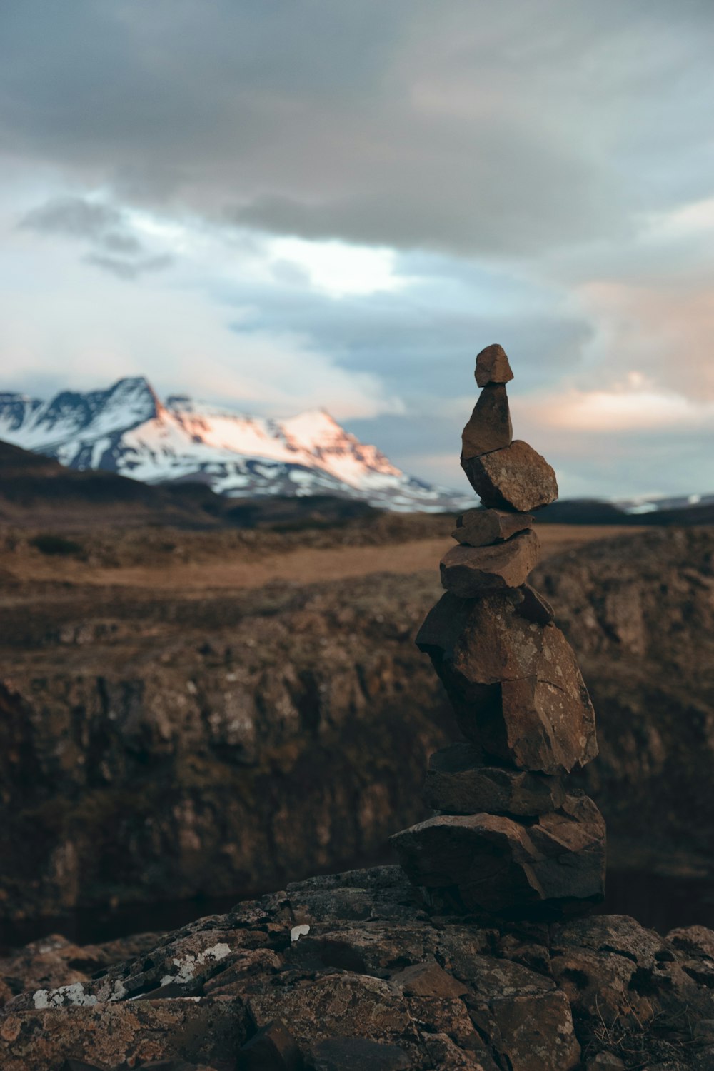 a stack of rocks with a mountain in the background