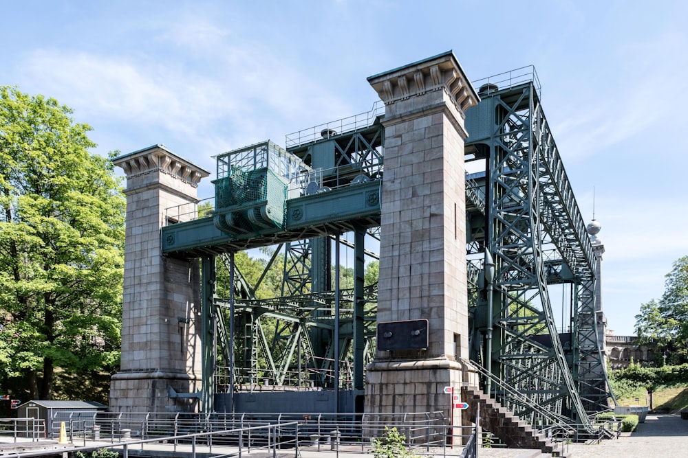 a large metal structure sitting on top of a lush green field