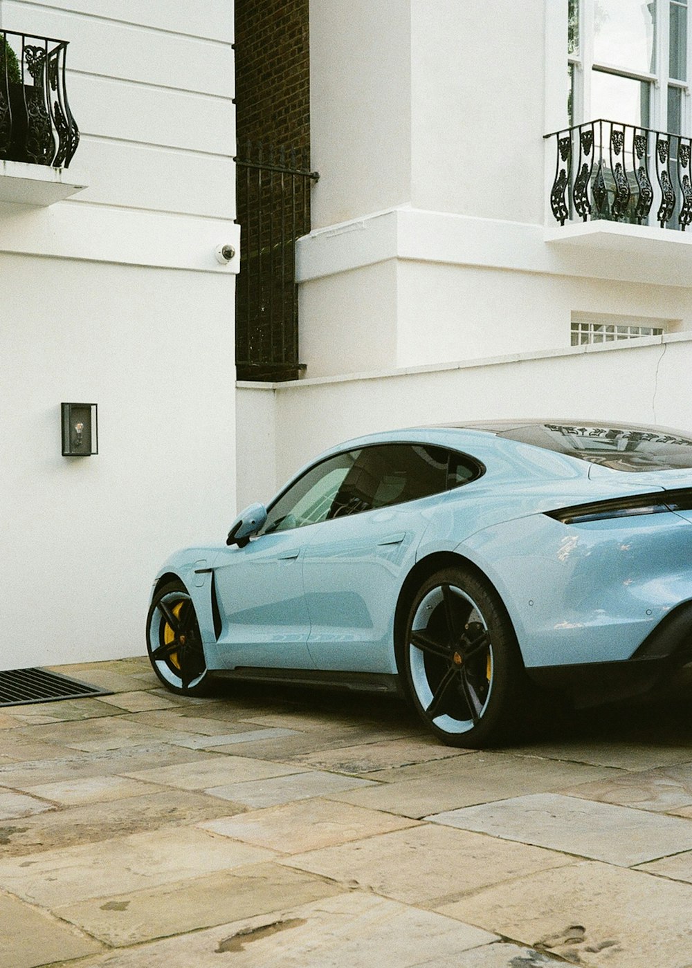 a blue sports car parked in front of a building