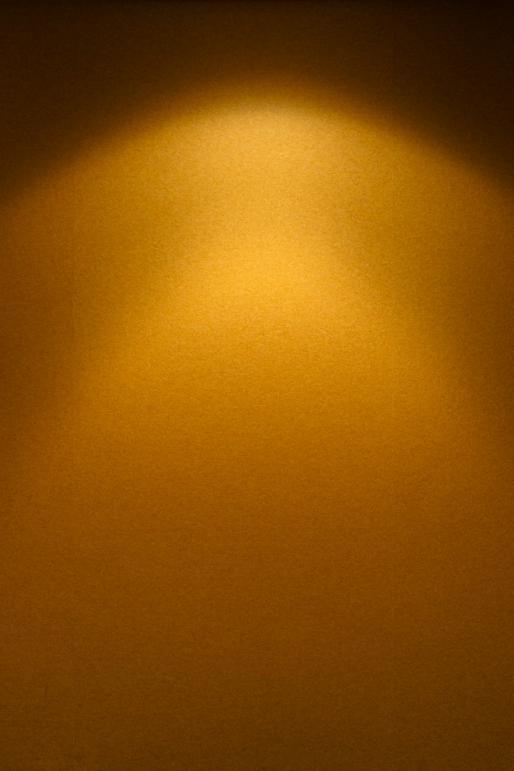 a yellow wall with a light shining on it