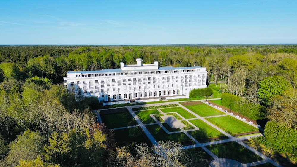 an aerial view of a large white building surrounded by trees
